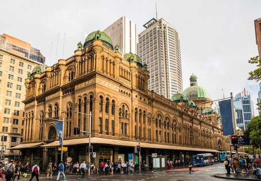 The Queen Victoria Building in the afternoon sunlight with pedestrians crossing Market Street