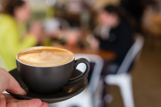 flat white in hand at cafe