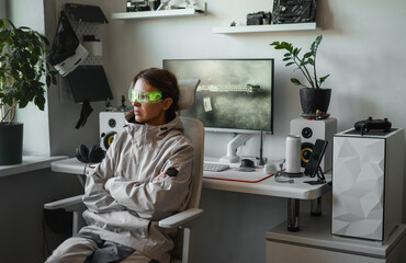 Focused woman explores AR interface using smart glasses in minimalist gaming setup. Scene reflects future-ready interaction, wearable vision and digital security