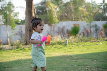 Little kid playing in garden area or park	