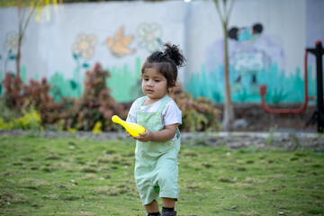 Little kid playing in garden area or park