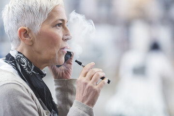 Senior female using electronic cigarette