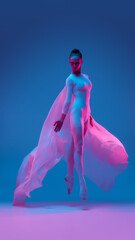 Graceful ballerina dancer leaps through neon light wrapped in floating fabric, symbolizing...