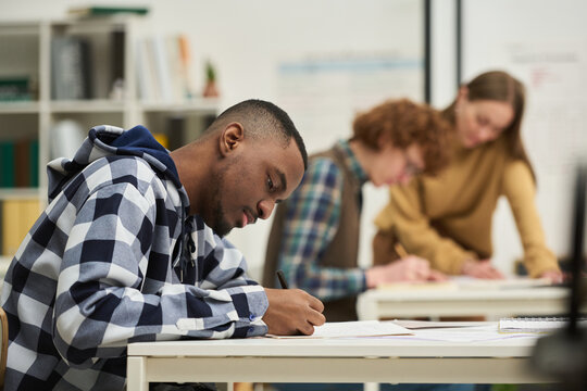 Young people in classroom setting, studying foreign languages with focus and concentration. Collaborative environment conducive to learning, with books and materials on desks
