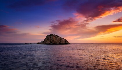 Fototapeta premium A small rocky island sits in calm waters under a vibrant, colorful sunset sky.