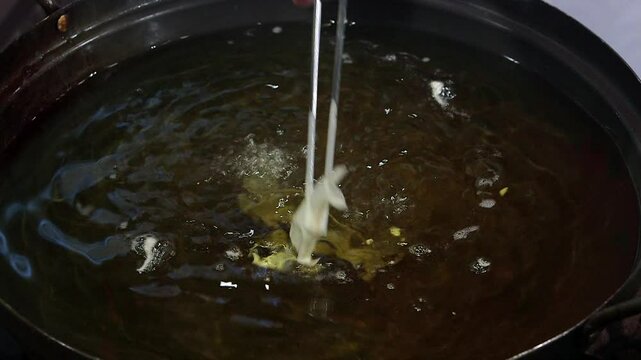 Sweetfish being coated and fried in batter