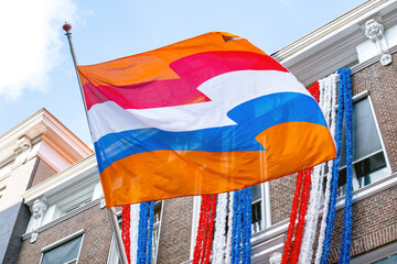 Flag Netherlands blue sky old city Holland building Den Haag Koningsdag orange