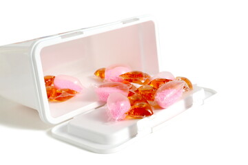 On a white background there are washing capsules with packaging.