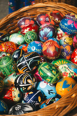 A woven basket brimming with intricately decorated Easter eggs, a colorful celebration of spring.