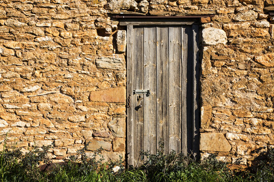 Weathered door in stone wall