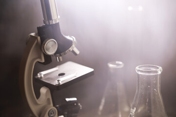 Vintage Microscope and Glass Beakers in Scientific Laboratory with Soft Lighting