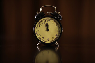 Vintage Analog Alarm Clock Showing Midnight or Noon in Low Light Setting