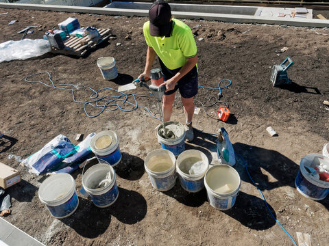 Concrete mixing and pool building with cement by hand with tradies