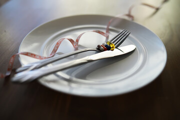 Diet Concept with Plate Utensils Tape Measure and Pills representing Nutrition and Weight Loss
