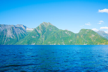 Nature in fjords. Norway. High mountains and reflections on the surface of the water. Place for mountain hiking, travel and vacation. Wallpaper, postcard, background.