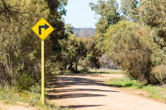 Sharp bend sign on unsealed country road