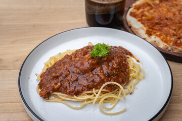 Delicious spaghetti bolognese on white plate on cafe table.