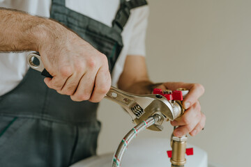 Man fixing water heater using wrench