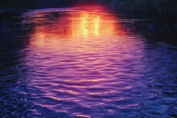 Sunset reflecting on calm water, creating a vibrant purple and orange gradient.