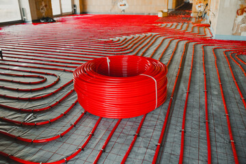 Red plastic pipes for floor heating system installation in new building
