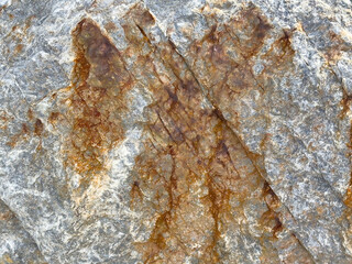 Rugged rock surface with natural brown streaks and textured patterns