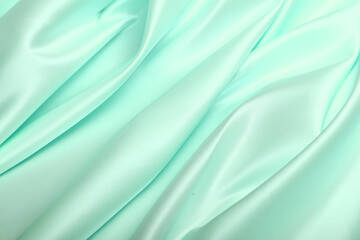 Close-up of luxurious turquoise-green American satin, known for its stiffness and elegant sheen. A premium textile perfect for structured garments, décor, and sophisticated fashion pieces.