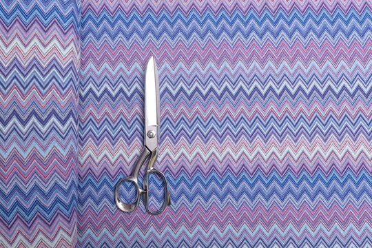 Top-down view of Missoni knit fabric showcasing its intricate texture and vibrant woven pattern. The premium material, known for its elasticity and elegance, is ideal for high-fashion garments.