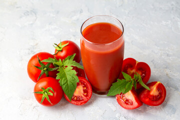Tomato juice in a glass and fresh tomatoes
