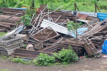 Metal and wooden construction materials are stacked haphazardly in an open area.