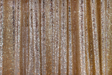 Fototapeta premium Golden sequins fabric used in fashion, interior design or event decoration with an elegant shimmering effect, glamorous textile background, inspiration for clothing or accessory creation or room decor