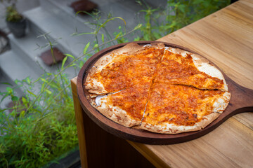 Delicious tuna pizza with spicy and savory taste on cafe table.