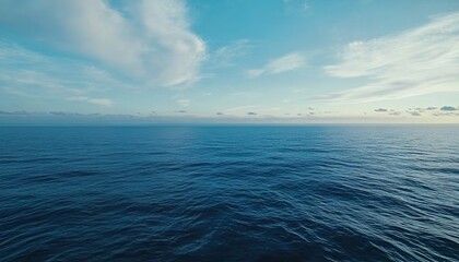 Fototapeta premium Calm sea under a blue sky with white clouds in horizontal composition.