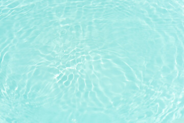 Blue water with ripples on the surface. Defocus blurred transparent blue colored clear calm water surface texture with splashes and bubbles. Water waves with shining pattern texture background.