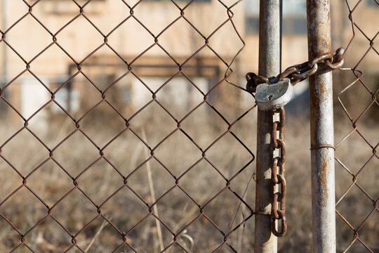 Rusty chain and padlock on metal gate