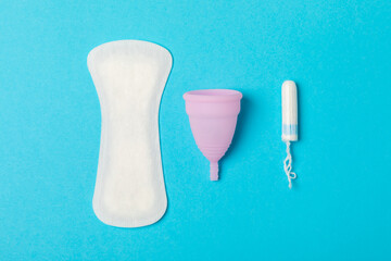 Menstrual cup on a bright background. Sanitary napkins, tampons and menstrual cup.Concept of critical days, menstruation.feminine hygiene product. Women health concept.Premenstrual syndrome.Copy space