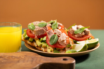 Tuna sandwiches on a table next to lemonade and beer, in a modern interior design