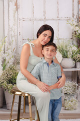 mother and son in green house posing for Mother's Day photos 