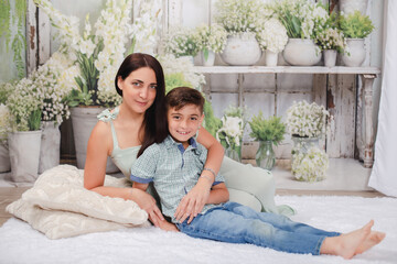 mother and son in green house posing for Mother's Day photos 
