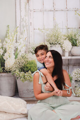 mother and son in green house posing for Mother's Day photos 