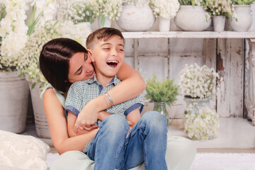 mother and son in green house posing for Mother's Day photos 