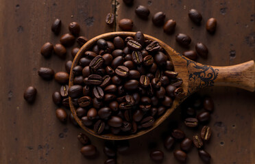 Obraz premium Wooden Spoon Filled with Coffee Beans on a Rustic Surface