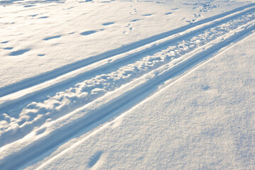 snowmobile track, snowmobile tracks in fresh snow on a sunny winter day