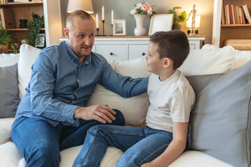 Family, smile or talking with dad and son on sofa in living room of home together for development....