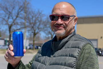 Adult man holding a drink can in a city