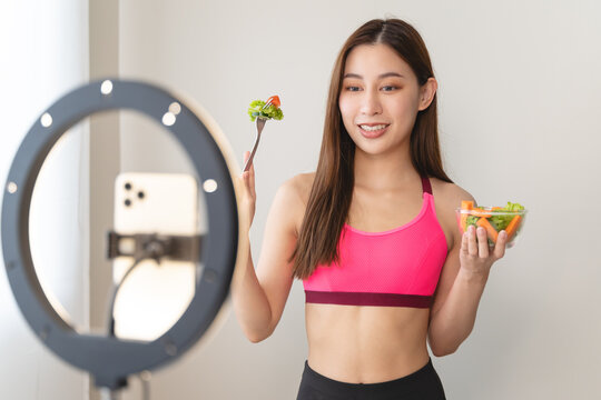 Asia healthy beautiful blogger influencer showing plant-based protein whey product on her live streaming channel to viral marketing brand online in wellness group follower.