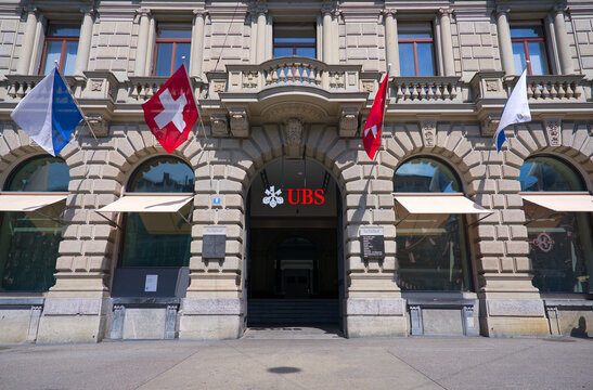 Bank building of Swiss bank named UBS at famous Parade Square at Swiss City of Z&uuml;rich on a sunny spring noon with Swiss flags. Photo taken April 28th, 2025, Zurich, Switzerland.