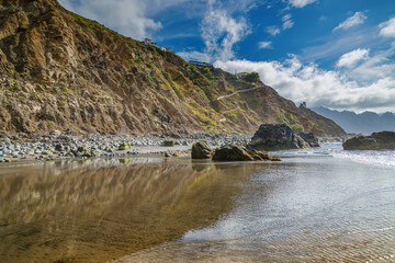 Fototapeta premium Scenic view of coastal cliffs reflected in the calm sea in Playa Benijo, Tenerife