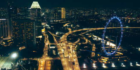 Aerial view of illuminated expressway city skyline at night with bright lights, showcasing modern urban architecture lifestyle, futuristic development, business hub infrastructure