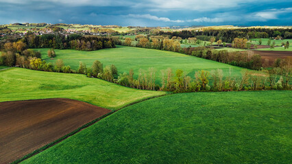 Village between spring fields in Allgäu, Germany aerial view
