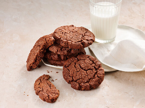 Delicious Freshly Baked Chocolate Cookies Served With Cold Milk on a Light-Colored Surface